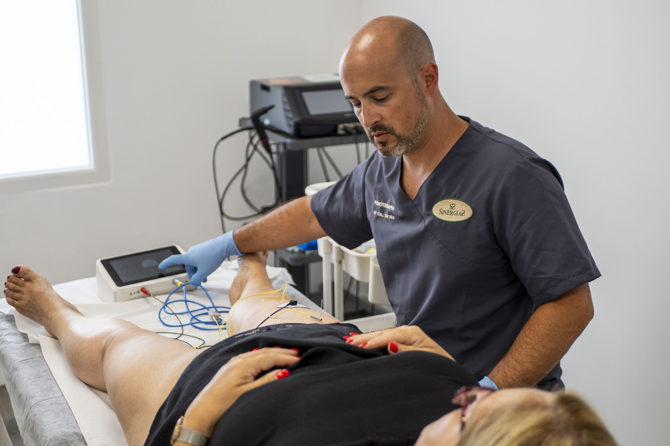 Ander Santa Coloma con una paciente realizando un tratamiento de fisioterapia con neuromodulación